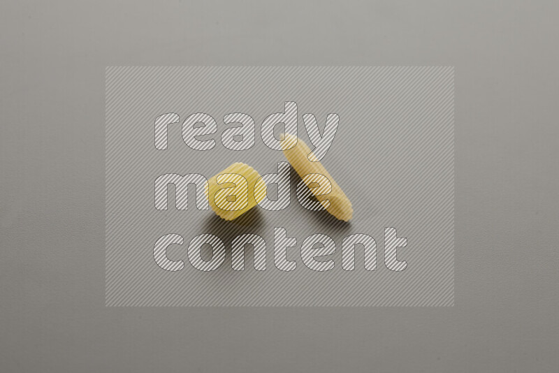 Big rings pasta with other types of pasta on grey background