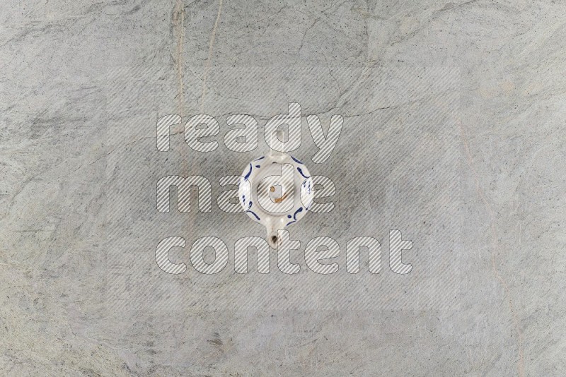Top View Shot Of A Pottery Teapot On Grey Marble Flooring