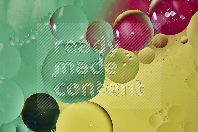 Close-ups of abstract oil bubbles on water surface in shades of yellow, red and green