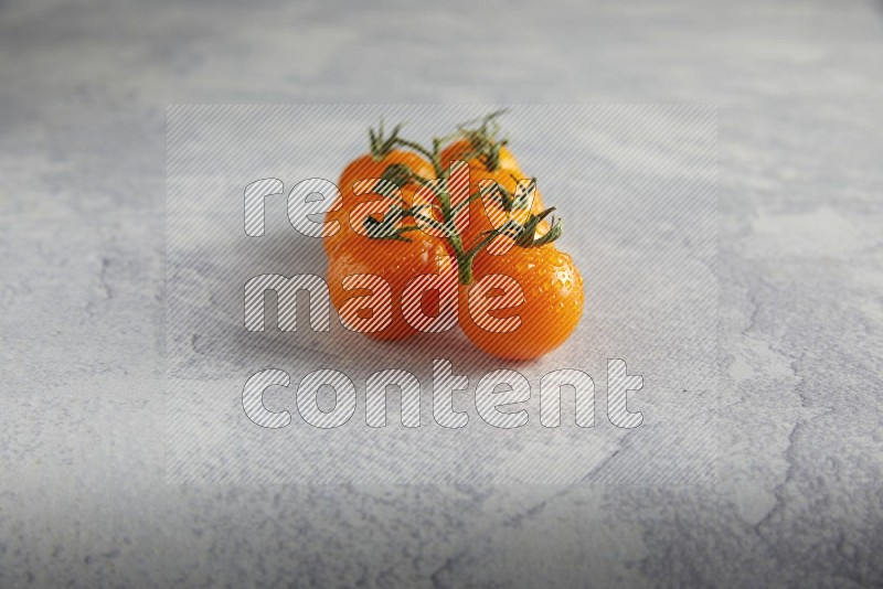 Orange cherry tomato vein on a light grey textured background 45 degree