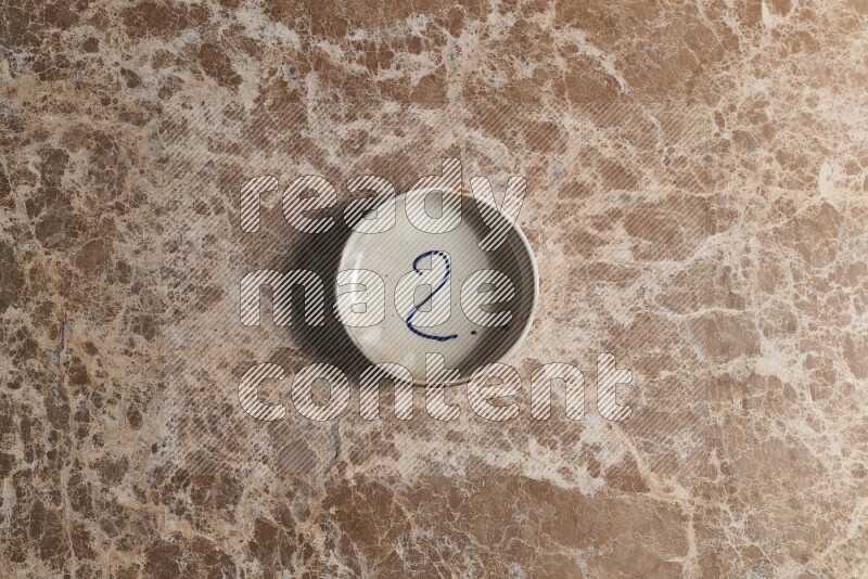 وعاء فخاري متعدد الألوان على خلفية من الرخام البيج