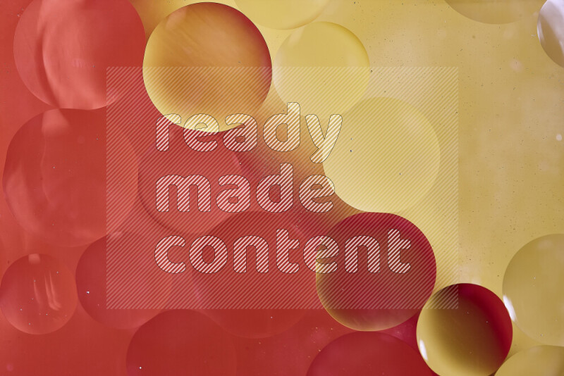 لقطات مقربة لفقاعات من الزيت على سطح الماء باللون الأحمر والأصفر