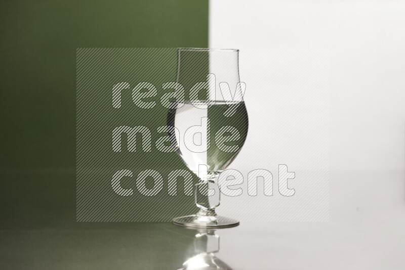 The image features a clear glassware filled with water, set against white and dark green background