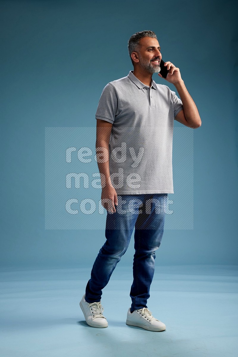 Man Standing talking on phone on blue background