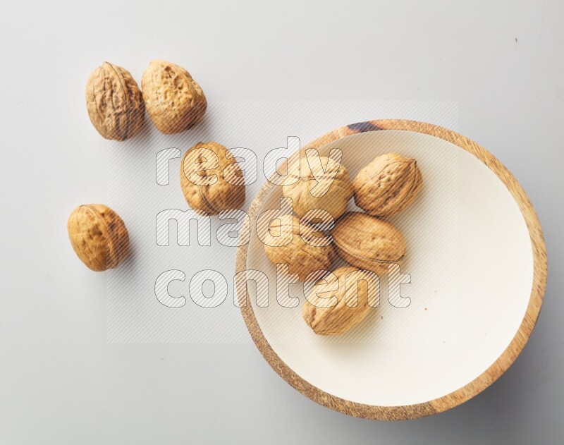 Top-view shot of walnut in a container on white background