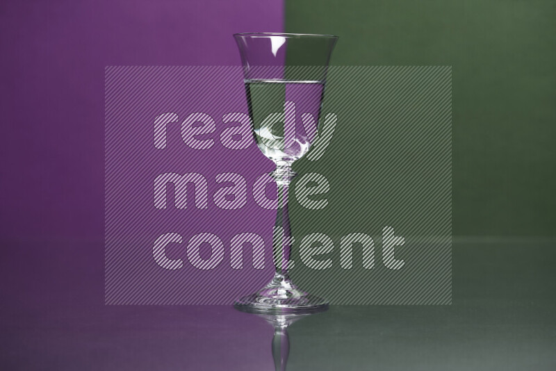 The image features a clear glassware filled with water, set against purple and dark green background