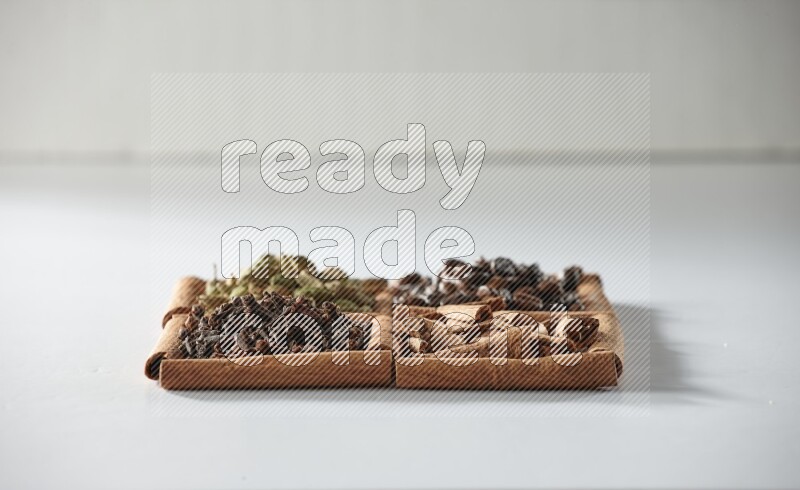 4 squares of cinnamon sticks full of coffee beans, cinnamon, cloves and cardamom on white flooring