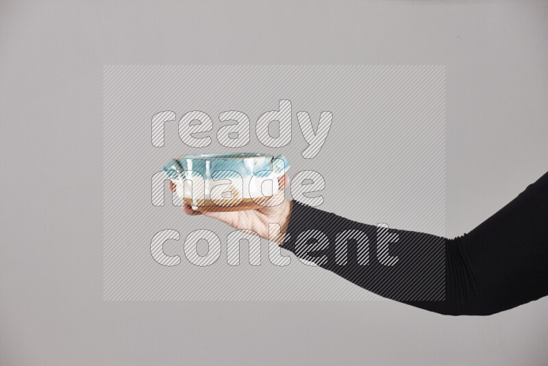 A woman in black abaya holding different pottery essentials in different positions