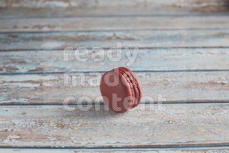 45º Shot of Red Velvet macaron on light blue wooden background