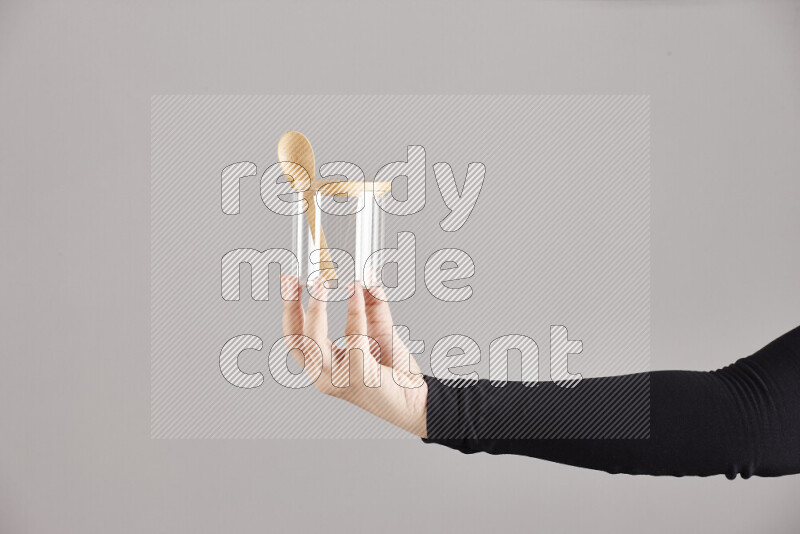 A woman in black abaya holding different glassware in different positions
