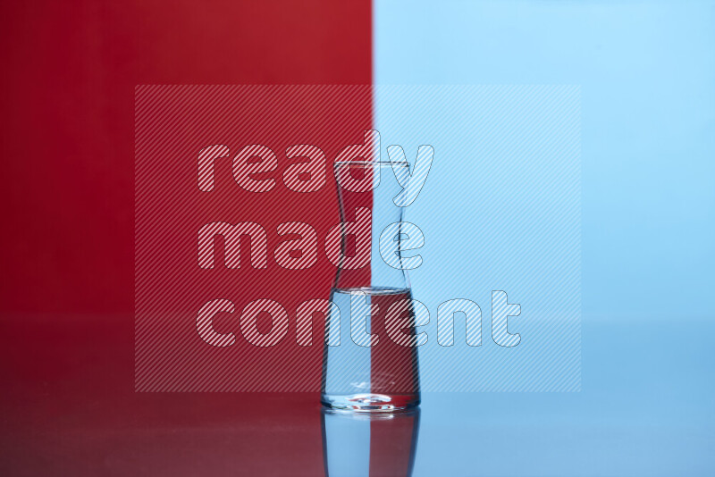 The image features a clear glassware filled with water, set against red and light blue background