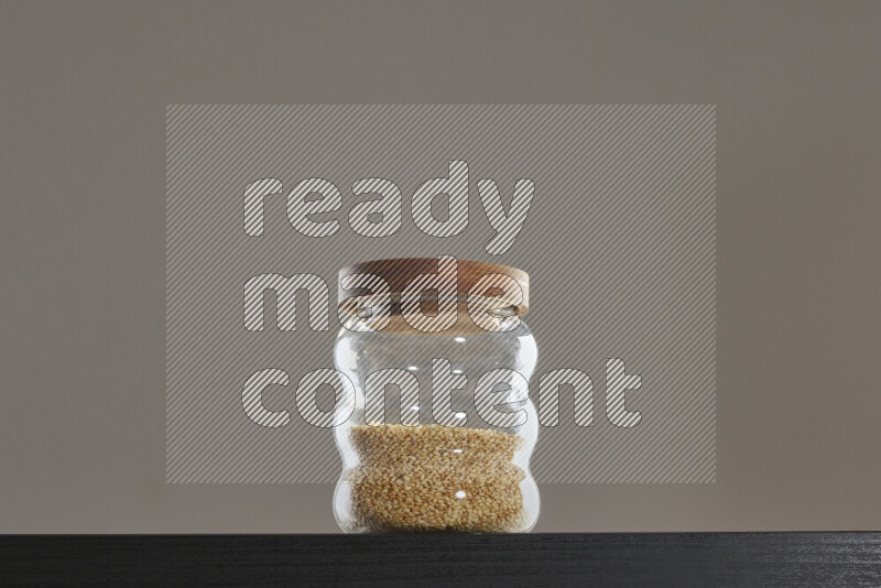 Sesame in a glass jar on black background