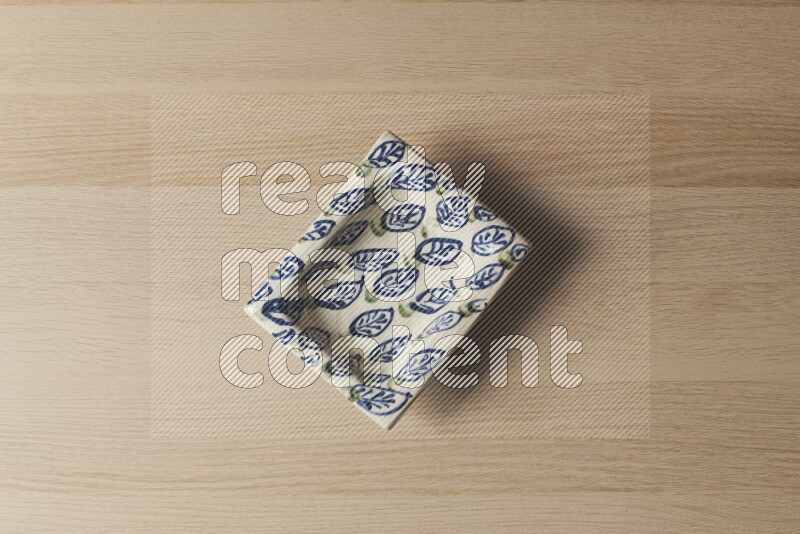 صحن فخاري مزخرف على خلفية خشبية فاتحة