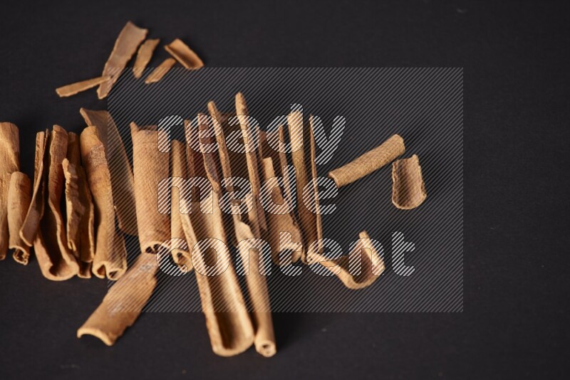 Cracked cinnamon sticks on a black background