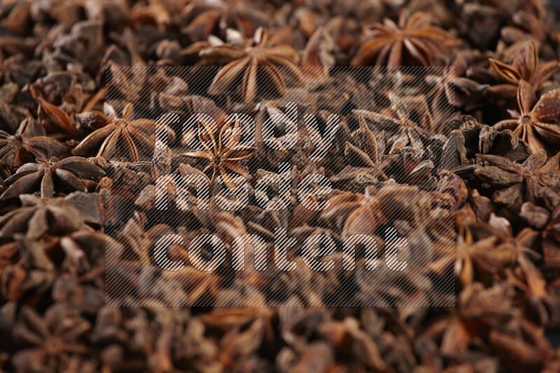 Star Anise herbs fill the frame on black flooring