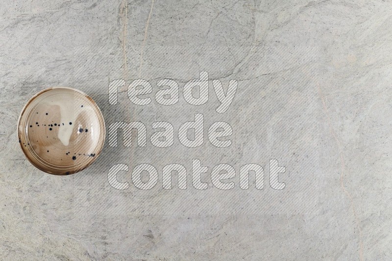 Top View Shot Of A Multicolored Pottery Bowl On Grey Marble Flooring