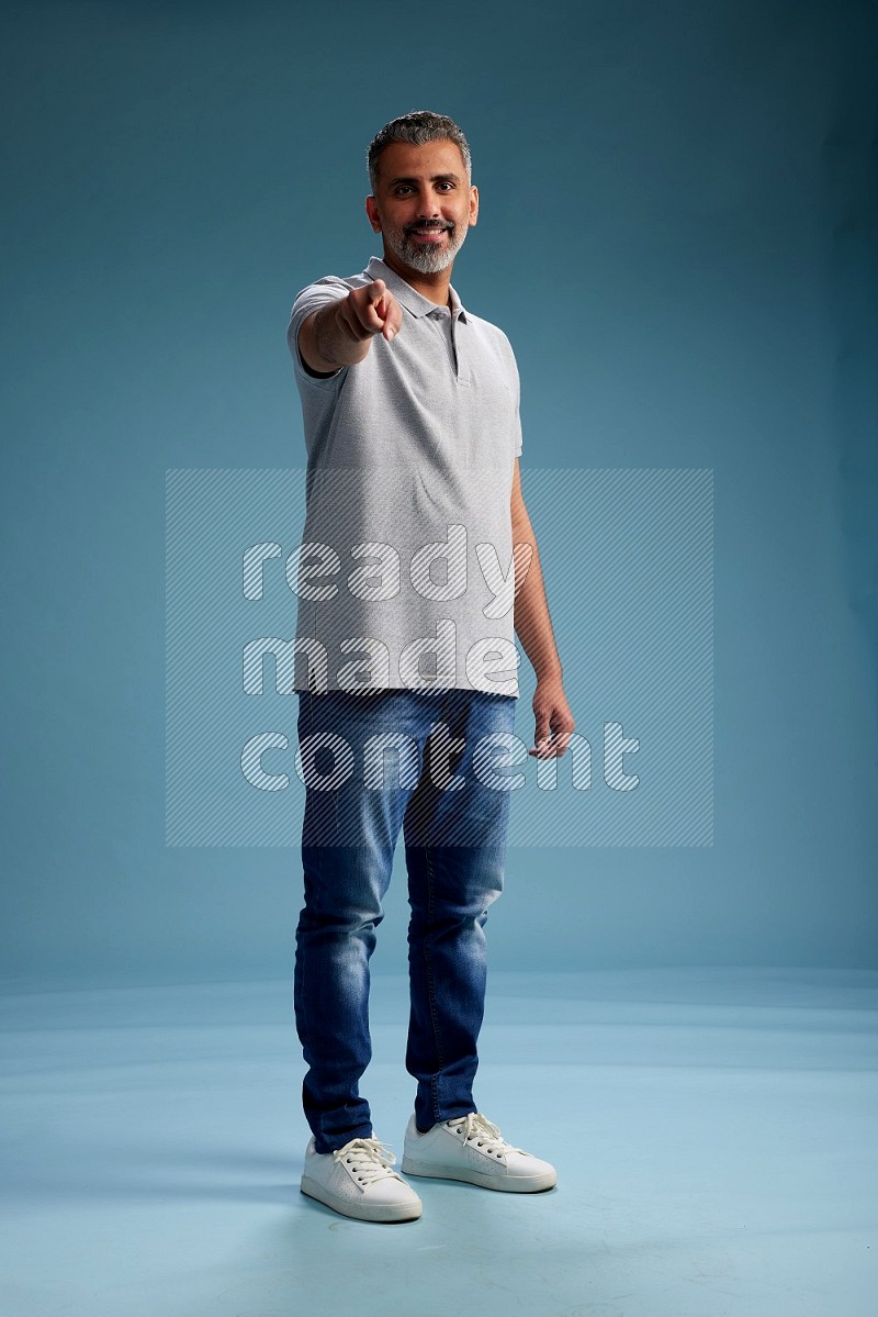 Man Standing Interacting with the camera on blue background