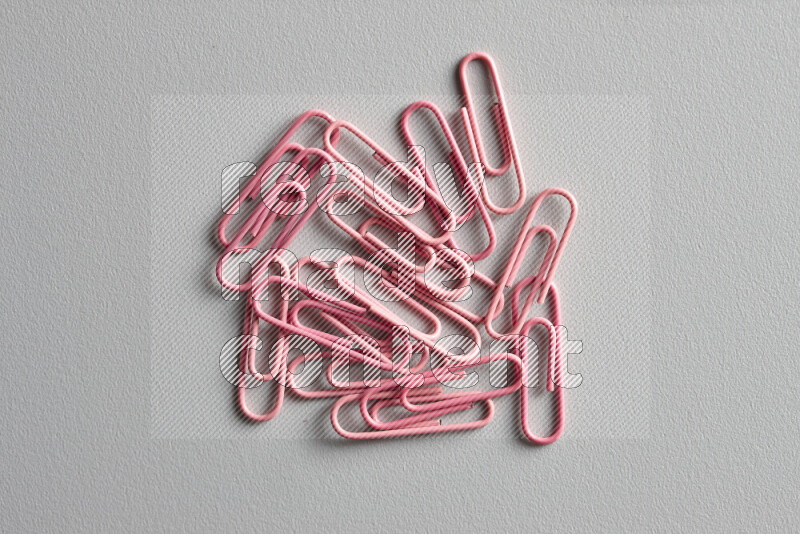 Pink paper clips isolated on a grey background
