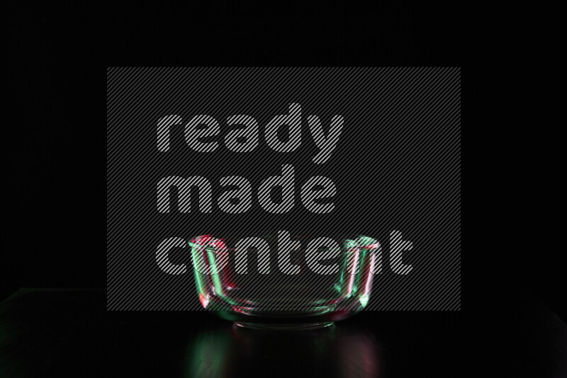 Glassware with rim light in red and green against black background