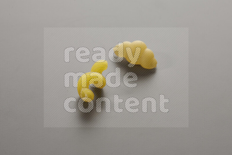 Twist pasta with other types of pasta on grey background