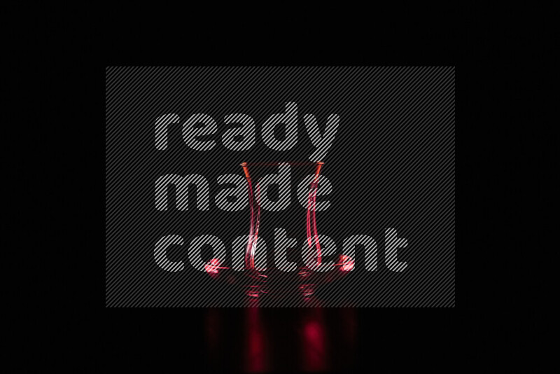 Glassware with rim light in red against black background