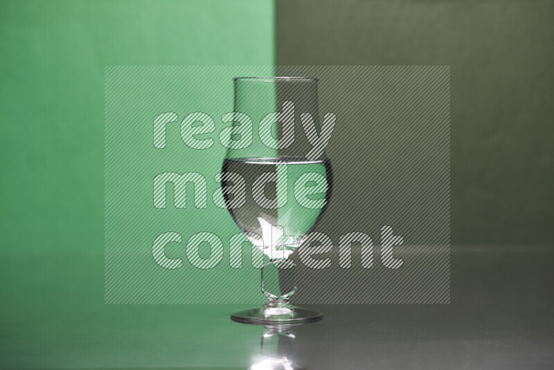 The image features a clear glassware filled with water, set against green and dark green background