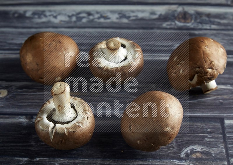 45 degree Cremini  mushrooms on a textured grey background