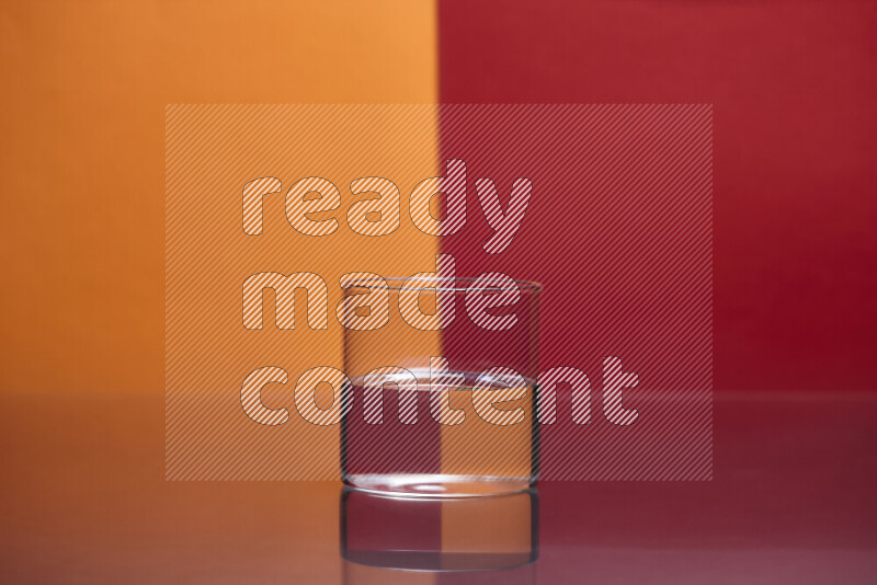 The image features a clear glassware filled with water, set against orange and red background