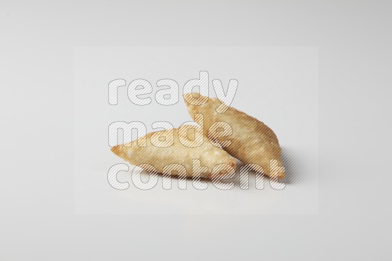 Two fried sambosas on a white background