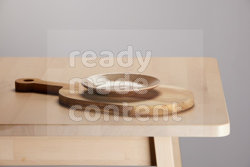 multi colored plate placed on a  wooden oval cutting board on the edge of wooden table