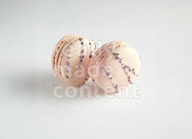 45º Shot of two pink orange blossom macarons on white background