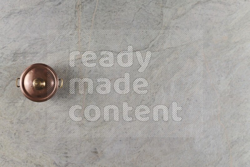 وعاء نحاسي صغير على خلفية من الرخام الرمادي