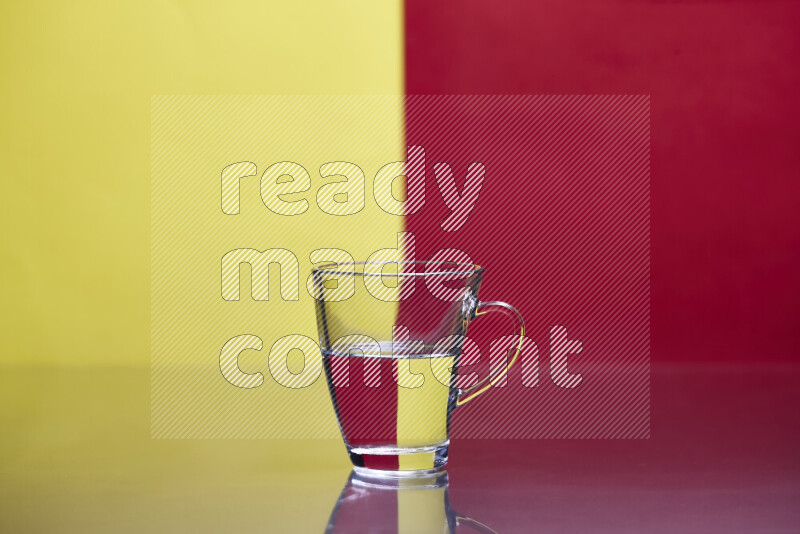 The image features a clear glassware filled with water, set against yellow and red background