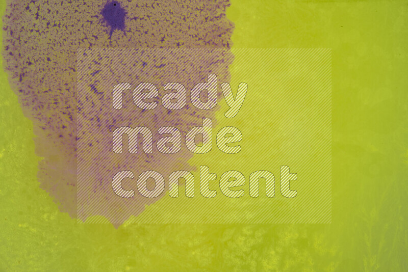 The image captures a dramatic splatter of purple paint over a yellow backdrop