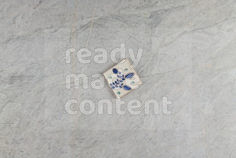 A decorative pottery coaster on grey marble background