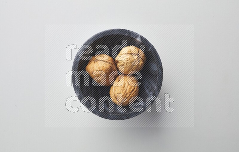 Top-view shot of walnut in a container on white background
