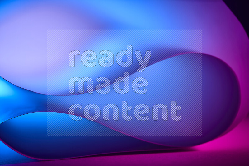 فن تجريدي يعرض منحنيات وتدرجات اللون الأزرق والوردي مكونه بضوء ملون