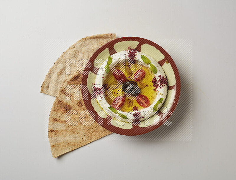 Lebnah garnished with Cherry tomato, mint & sumak  in a traditional plate on a white background