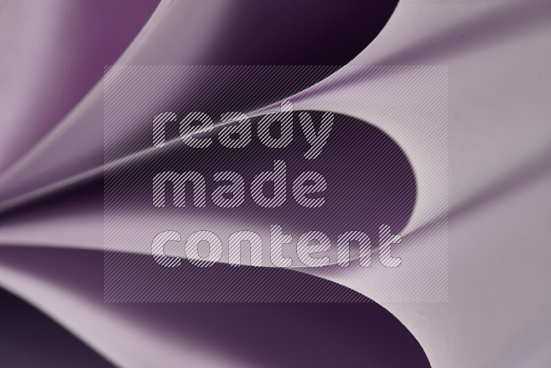 An abstract art showing purple paper sheets arranged in an overlapping curves