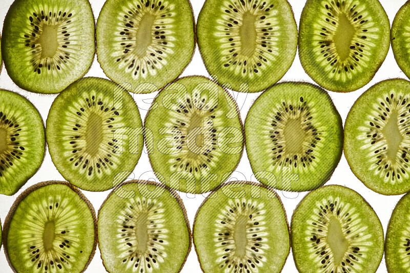 Kiwi slices on illuminated white background