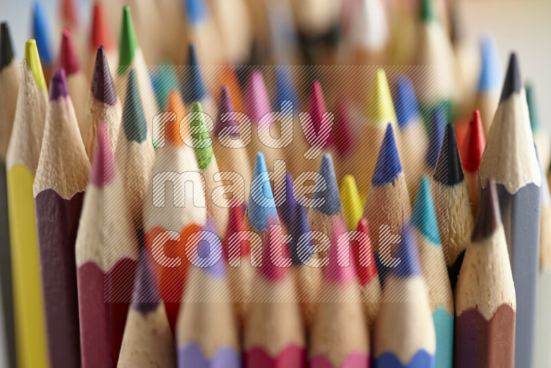 The image captures a close-up of sharpened colored pencils on multicolored background