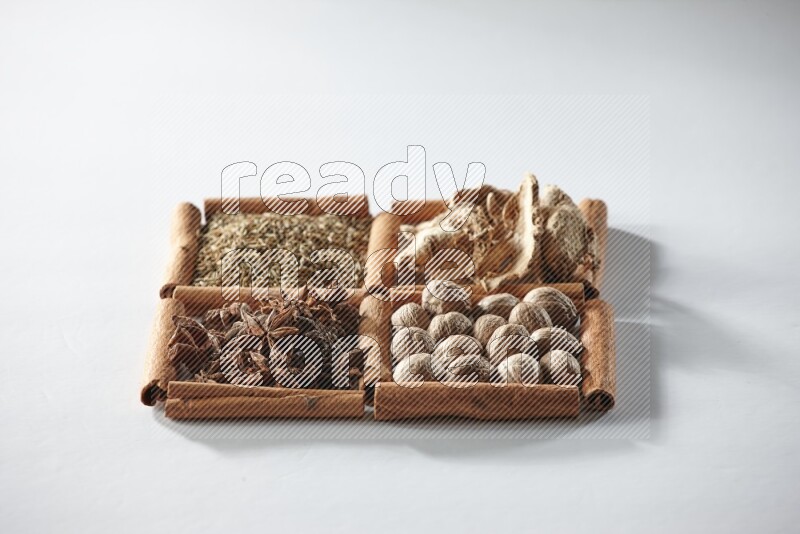 4 squares of cinnamon sticks full of star anise, ginger, cumin and nutmeg on white flooring
