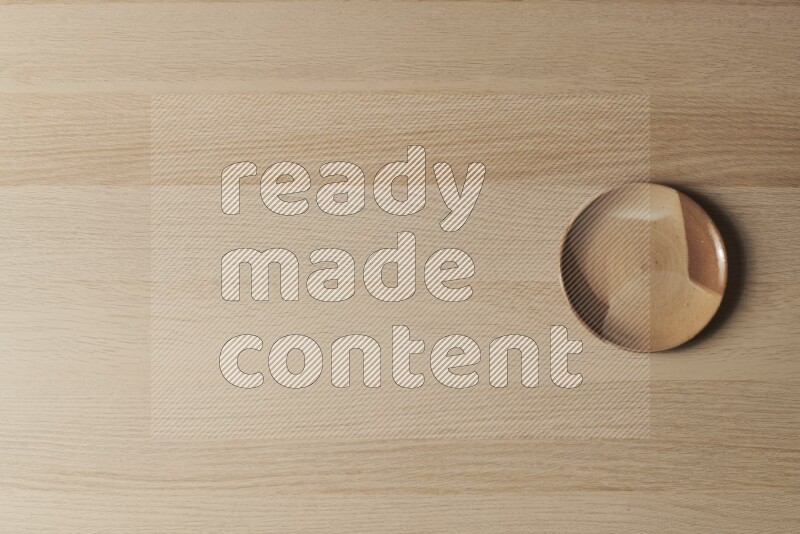 صحن فخاري متعدد الألوان على خلفية خشبية فاتحة