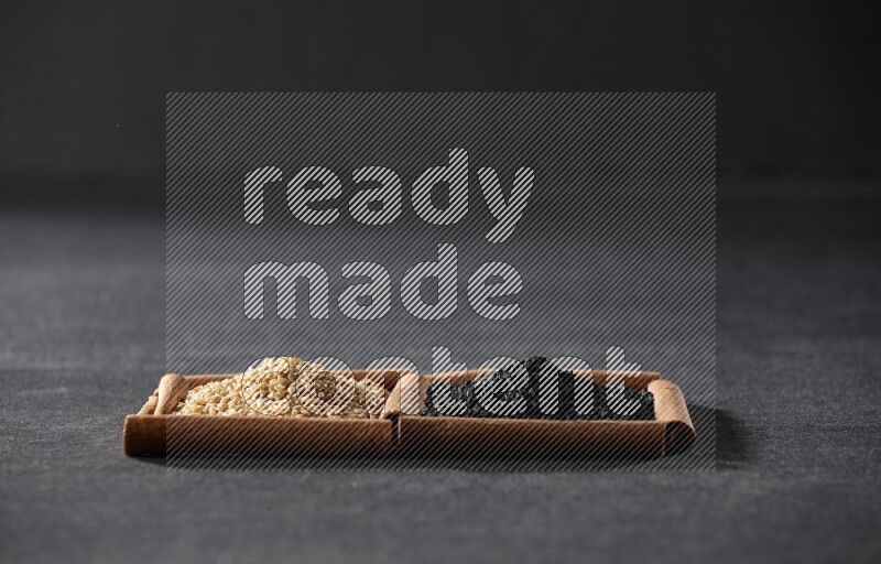 2 squares of cinnamon sticks full of sesame and black seeds on black flooring