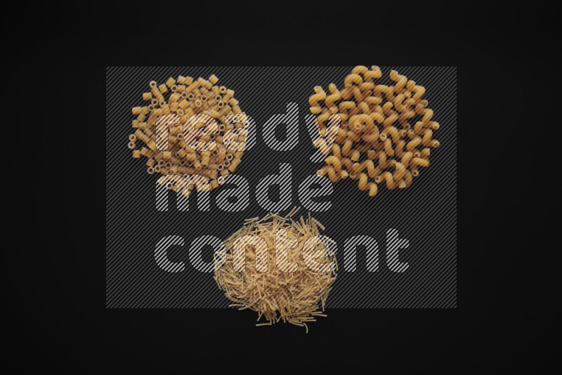 Different pasta types in bunches on black background