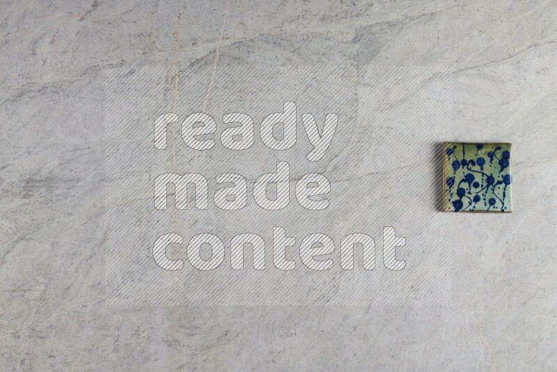 A decorative pottery coaster on grey marble background
