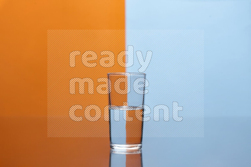 The image features a clear glassware filled with water, set against orange and light blue background