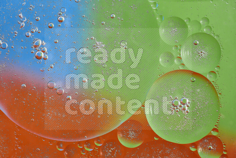 لقطات مقربة لفقاعات من الزيت على سطح الماء باللون البرتقالي والأخضر والأزرق