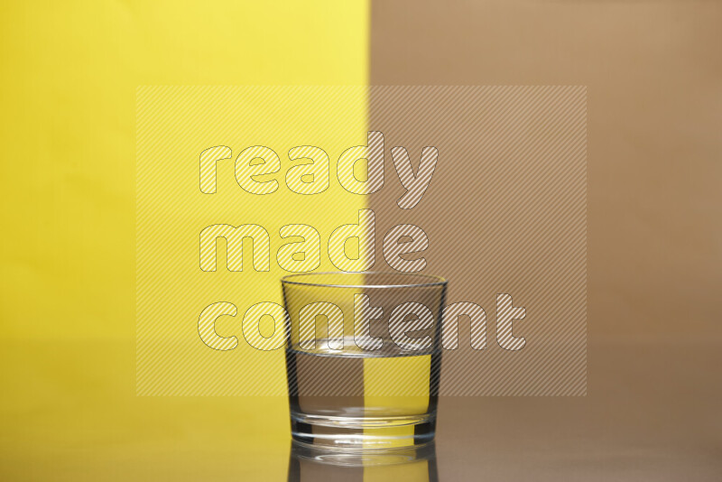 The image features a clear glassware filled with water, set against yellow and beige background