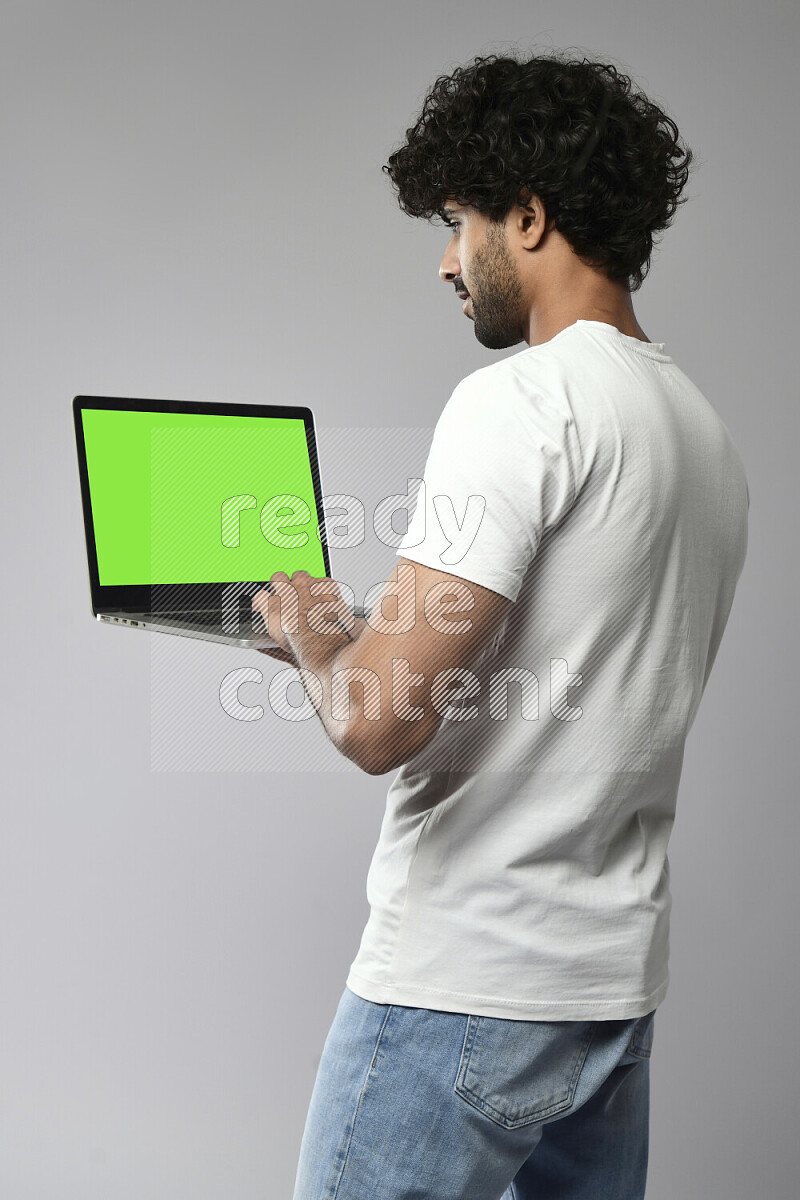 A man wearing casual standing and showing a laptop screen on white background